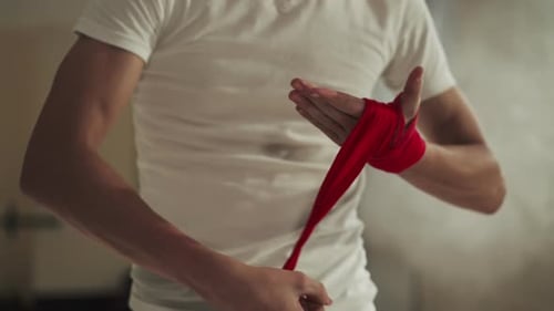 Boxer Covers Hand with Wrap for Boxing in Gym