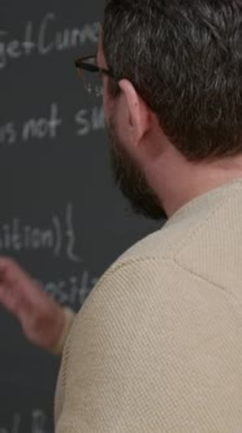 Vertical of Geeky Young Male Coding Teacher Explaining Script at Lesson