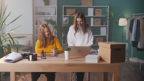 Young Women Working at Table with Laptop and Tablet
