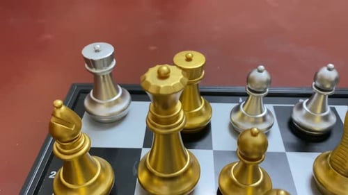 Close up view of silver and gold Chess set on classic black white board