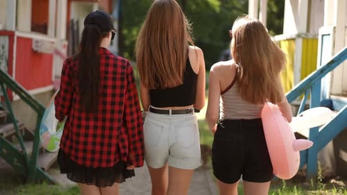 Slow Motion Rear View Three Girls in Sunglasses Walk Through the Recreation Center on a Sunny Summer