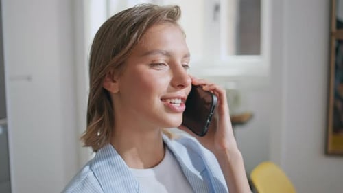 Smiling Woman Talking on Mobile Phone Indoors