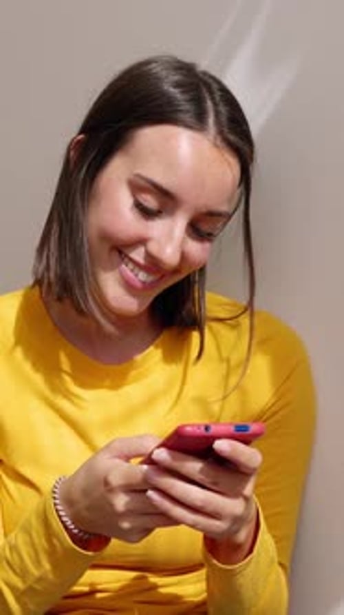 Smiling Woman Relaxing at Home Using Cell Phone Device