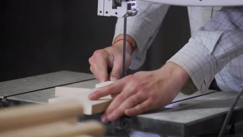 A man works with wood in a workshop. Working with wooden blanks. A man drills holes in wooden blanks