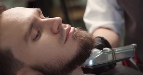 Man Receiving Beard Trim at a Barber Shop