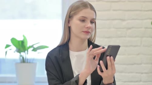 Young Woman Using Smartphone in Office Environment