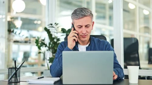 Successful Businessman Talking on Phone and Laptop in Modern Office