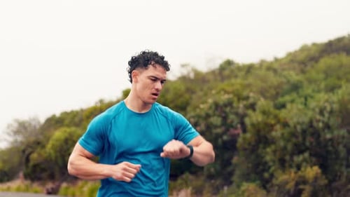 Man Jogging Checking Smartwatch Outdoors