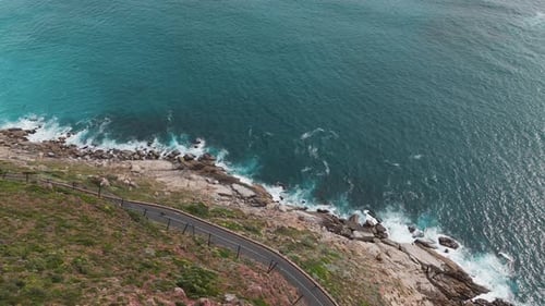 Mountain side drone clip of ocean and coastal road