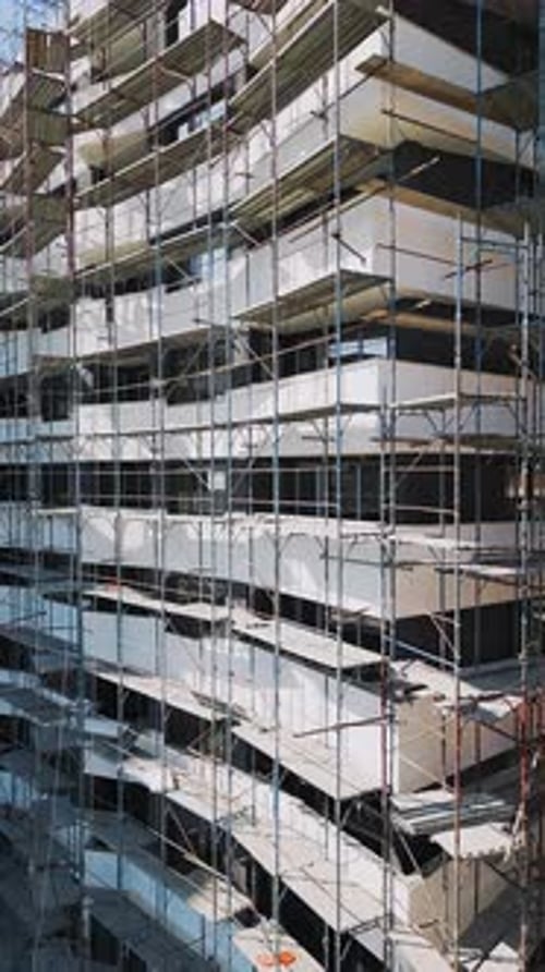 Construction Progress of a Modern Residential Building with Scaffolding in a Bustling Urban Area