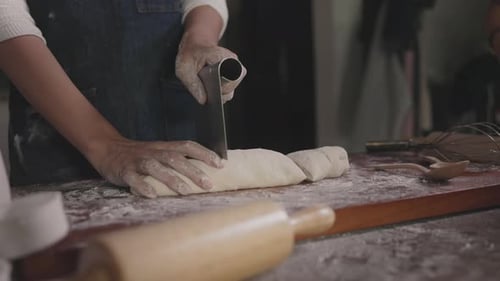 Der Bäcker teilt den Teig in Portionen und Gewichte auf, um Brot von Hand zu backen