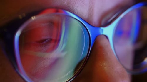 The Close Up of Woman Eyes Looking Through Glasses at Flashing Sliding Lights