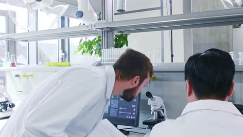 Scientist and His Assistant Working in Lab Doctor Teaching Intern to Make Analyzing Research