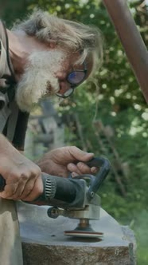 Vertical of Artisan Using Angle Grinder to Polish Natural Stone