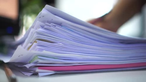 Stacks of paper files for searching information on work desk office by Businesswoman hands working