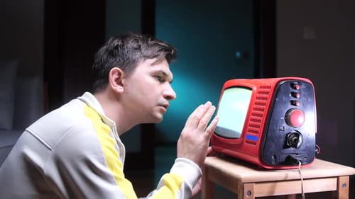 Man Interacting with an Old Television Set