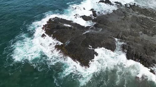 Waves Crashing on Rocky Shore From Above