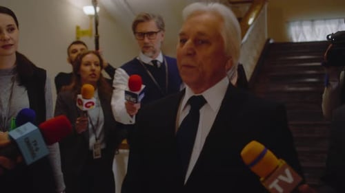 Politician Giving a Press Conference Surrounded by Reporters