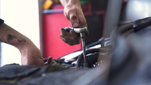 Mechanic Repairing Car Engine with Socket Wrench