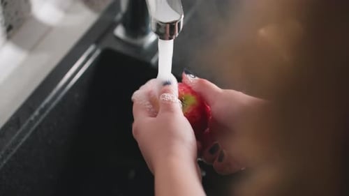 Woman Washing Fresh Red Apple Under Running Water
