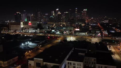 Cinematic aerial drone footage of Los Angeles at night, featuring the iconic downtown skyline