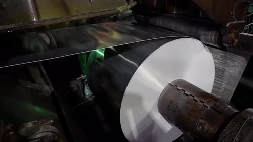A mechanical press extrudes aluminum can blanks from food-grade aluminum foil. Production of aluminu