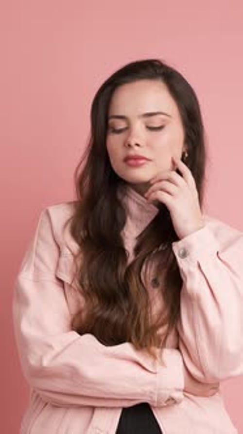 Woman Posing in Thoughtful Studio Portrait on Pink