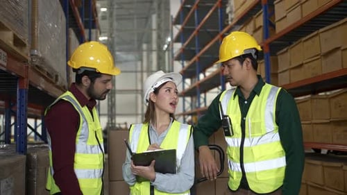 Blue collar workers are working at warehouse.