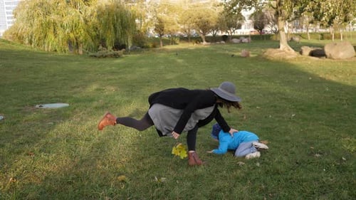 Stylish Happy Mother and Little Son Playing in the Park Together