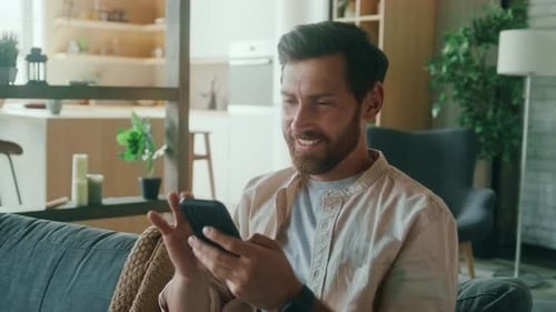 Happy Man Using Cell Phone at Home