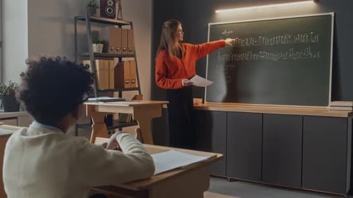 Boy Raising Hand and Answering Question of Young Teacher in Music Class