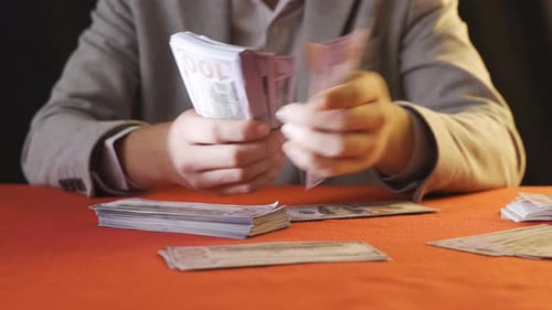 Adult Counting Stack of United States Currency