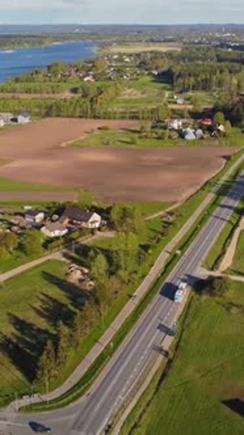 Vertical slow drone pull away over Katlakalns spring residential area, traffic on Daugmale road