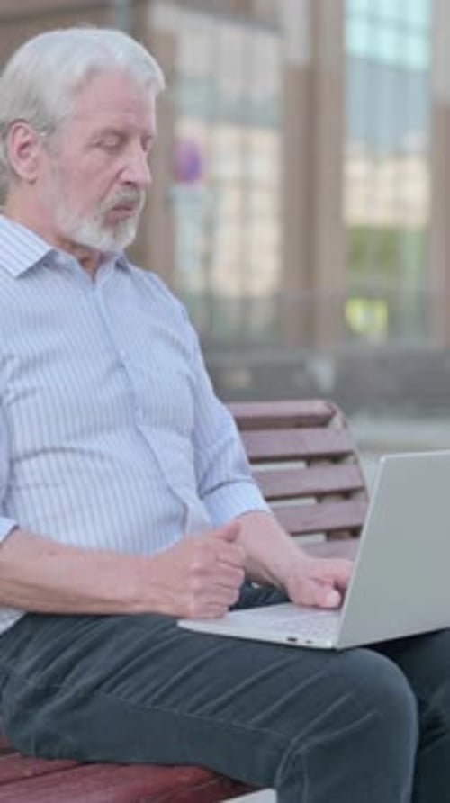 Senior Man Video Calling on Laptop Outdoors