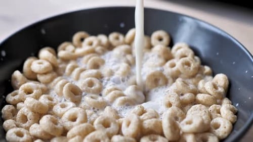 Milk Pour Into Dry Breakfast in the Form of Rings in a Blue Bowl Dry Healthy Breakfast Sweet