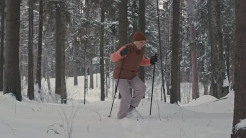 Elderly Woman Hiking in Snowy Forest