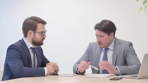 Businessmen Meeting Shaking Hands in an Office