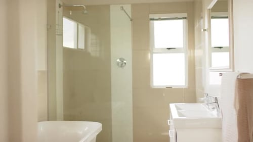 General view of modern bathroom with shower cabin, bathtub and washbasin, slow motion