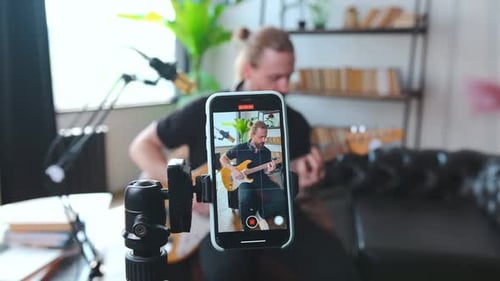 Man Playing Guitar Recording Video on Smartphone