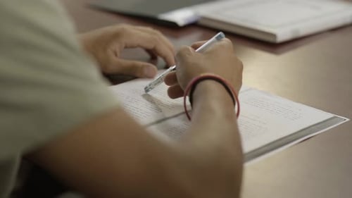 Un estudiante intenta responder a una prueba, con un primer plano en la mano, El alumno juega con el bolígrafo, Idioma hebreo