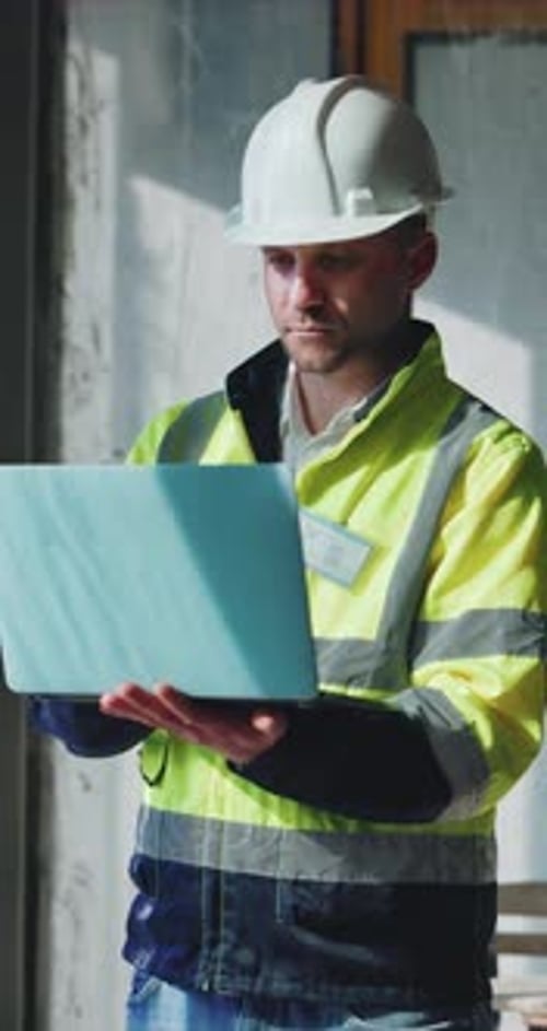 Construction, thinking and man on laptop in building for planning, research and online blueprints