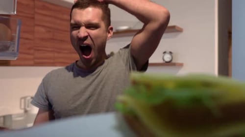 Tired Man Takes Sandwich Bite From Refrigerator