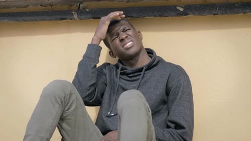 Un jeune homme noir africain endormi est réveillé par la lumière du soleil