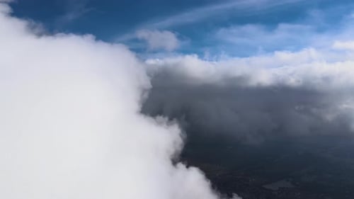 Aerial View From Airplane Window at High Altitude of Earth Covered with White Puffy Cumulus Clouds