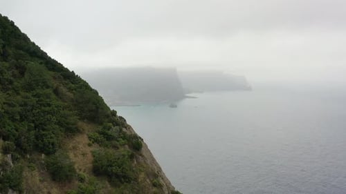 Revealing Aerial View, Hills and Misty Coastline of Madeira Island, Portugal, Rainy Clouds and Skyli