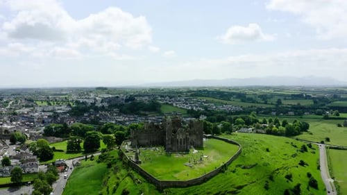 Aerial view pulling away from the Rock of Cashel in Ireland's countryside.