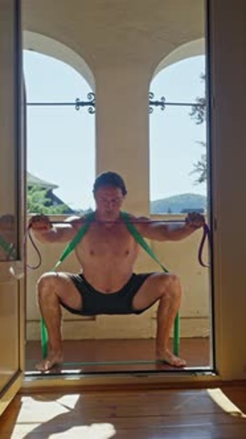 Man Exercising with Resistance Bands in Doorway