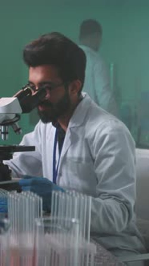Scientist Uses Microscope in Bright Laboratory Setting