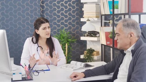 Female doctor talking to her elderly patient at the hospital.