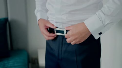 Man Adjusting Belt Buckle Indoors